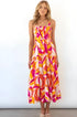 Woman wearing a colorful sleeveless Charlotte Day Dress with vibrant pink, orange, and yellow patterns, perfect for summer and beach outings.