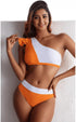 Woman wearing a stylish orange and white one-shoulder Long Island Bikini with high waist bottom and fitted spandex fabric.